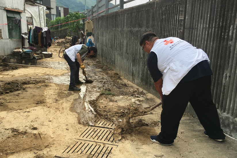 義工及職員正協助居民清理排水口，回應居民需要，改善區內備災設施。